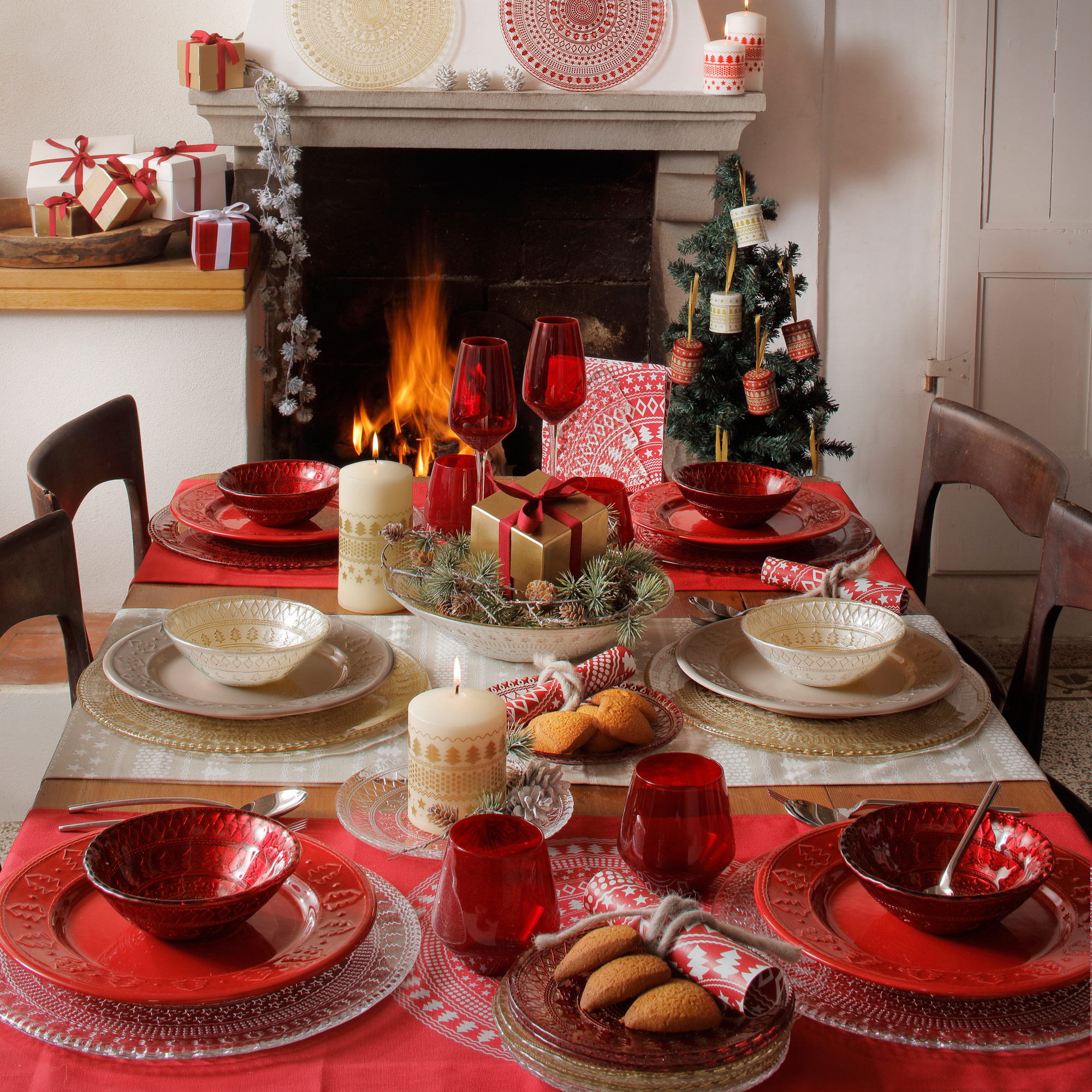 tavola natalizia addobbata con accessori e piatti ivv sulo sfondo il caminetto acceso